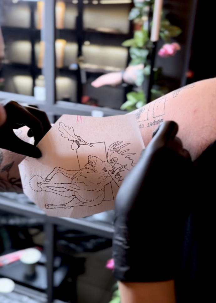 Placing a tattoo stencil on the arm